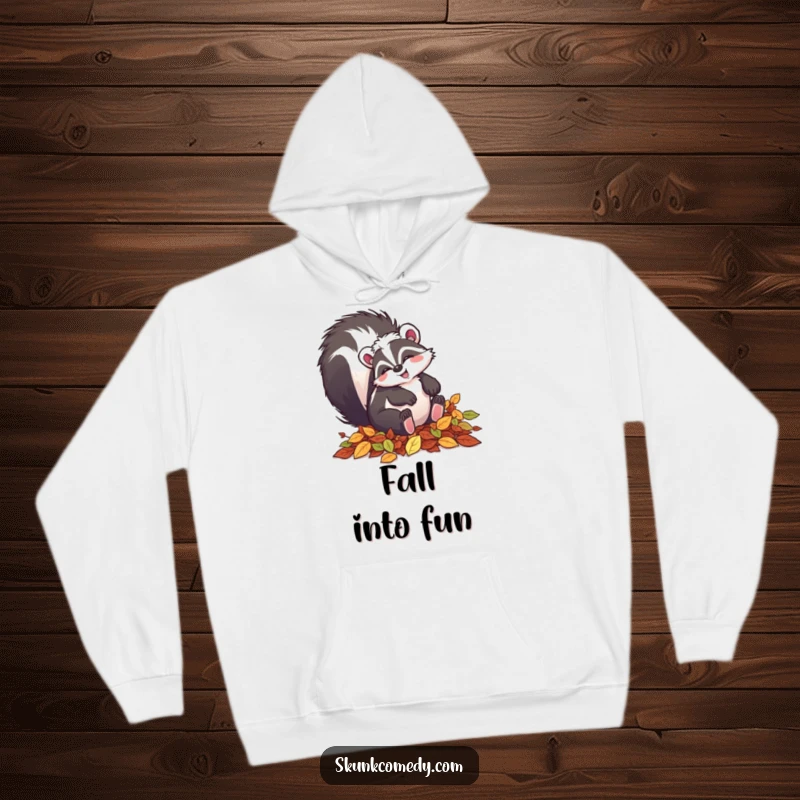 Funny skunk hoodie showing a happy skunk playfully tumbling in a pile of colorful autumn leaves.