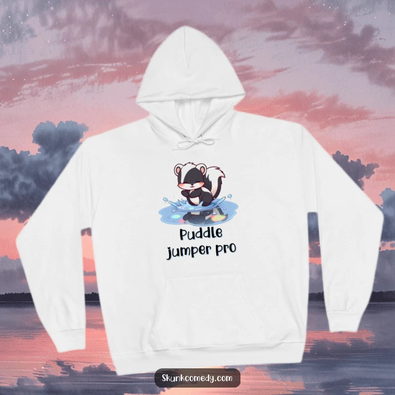 Funny skunk hoodie showing a skunk joyfully splashing in a puddle with beautiful rainbow reflections, a cozy and humorous clothing item.