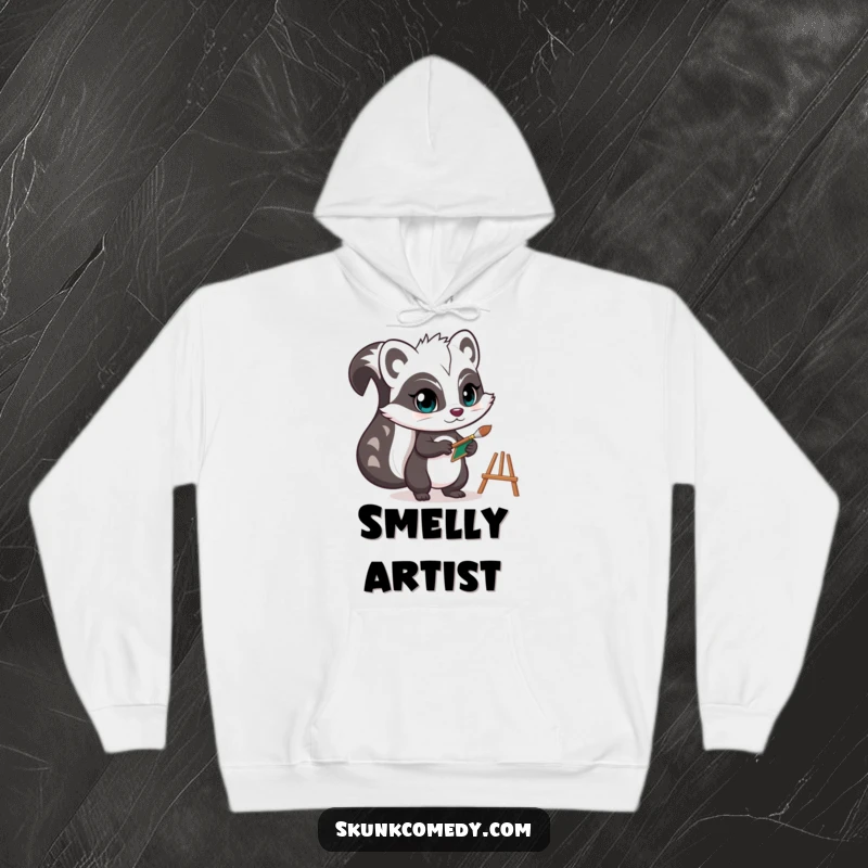 Funny skunk hoodie displaying a determined artist skunk holding a tiny paintbrush and easel, offering cozy comfort with creative charm.